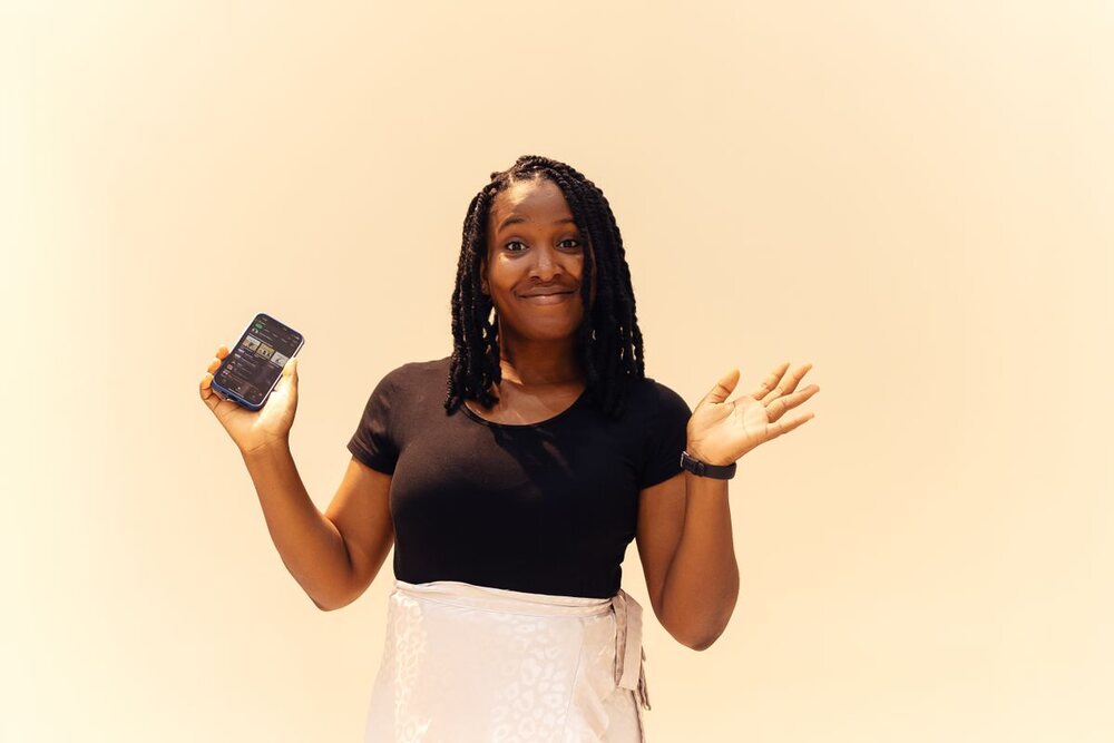 A Nigerian woman sending a message on her phone